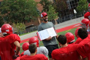 BRIAN BAKER/TOWN CRIER INTRODUCING THE PLAYBOOK: North Toronto CI coach Shawn Hood talks to his charges during a September practice.